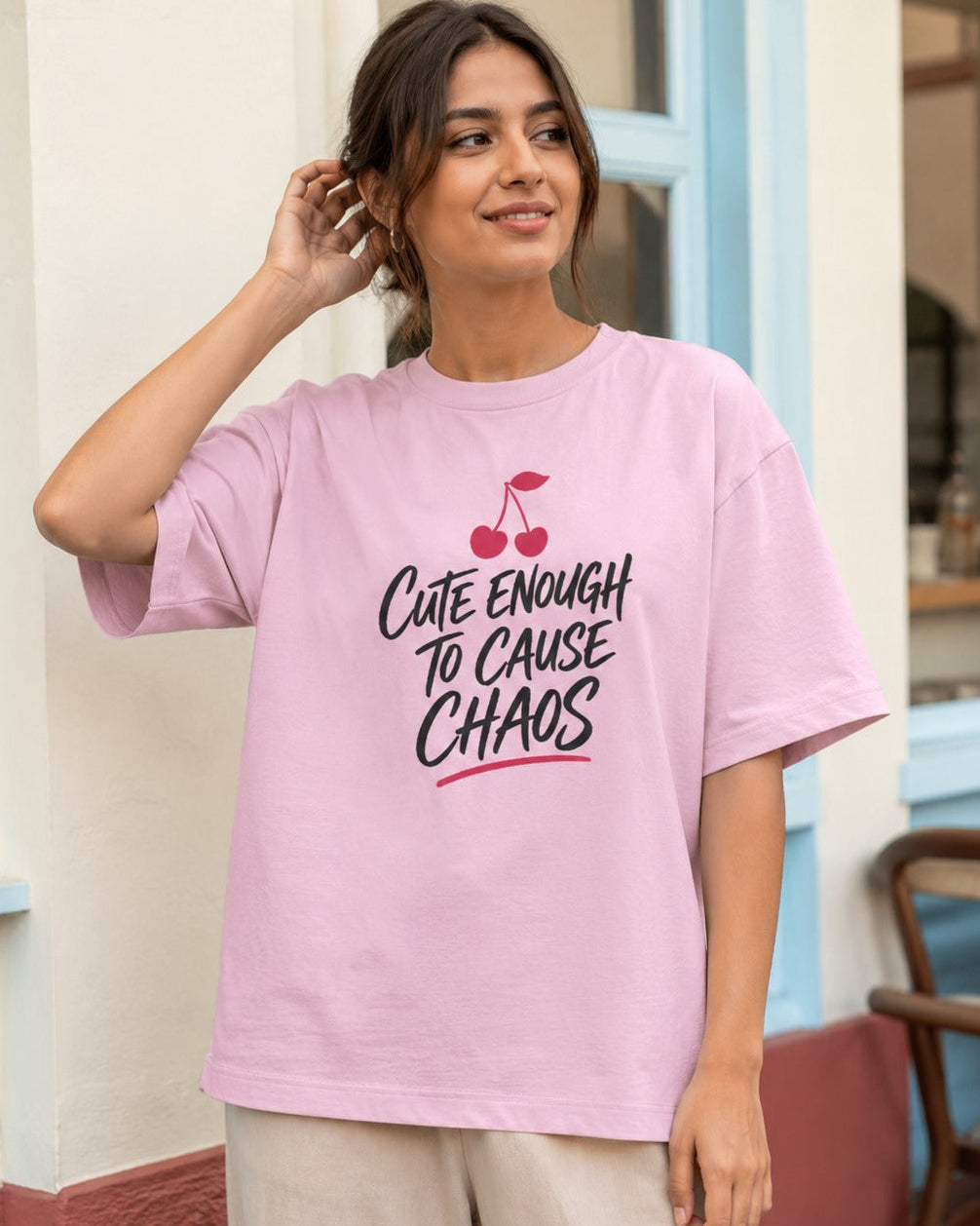 Model wearing Cute Enough to Cause Chaos oversized T-shirt in light baby pink